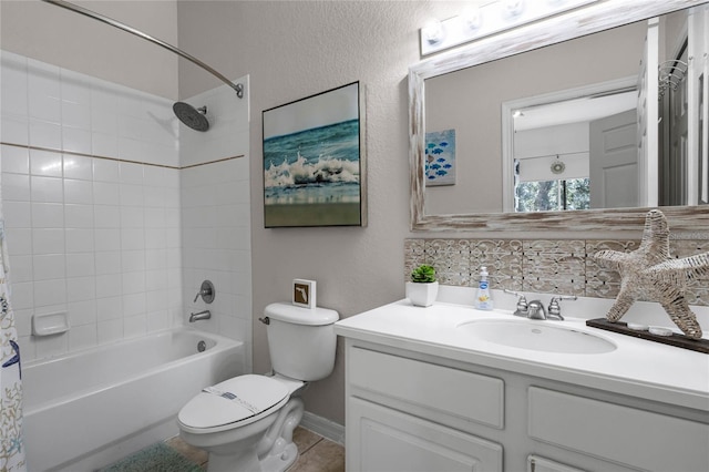 full bathroom with vanity, backsplash, tile patterned floors, tiled shower / bath, and toilet