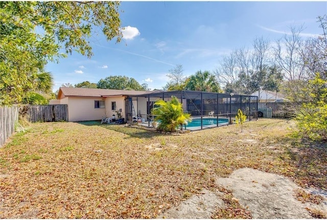 back of house with a fenced in pool, glass enclosure, and a lawn