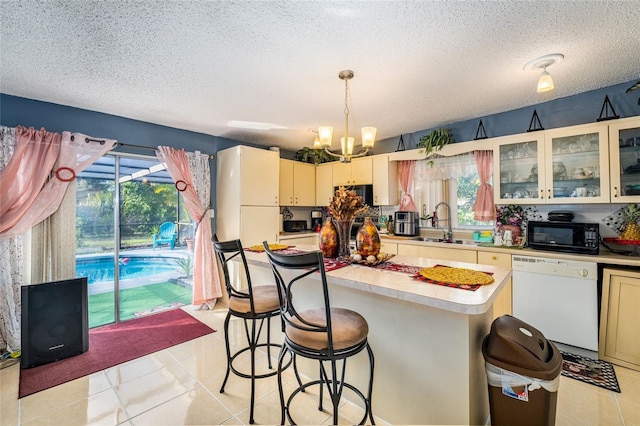 kitchen featuring white dishwasher, a healthy amount of sunlight, and light tile patterned flooring