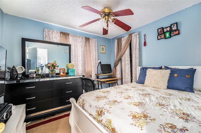 carpeted bedroom featuring ceiling fan and a textured ceiling