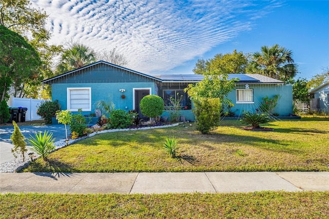 ranch-style home featuring a front yard and solar panels