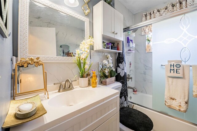 full bathroom with vanity, backsplash, toilet, and bath / shower combo with glass door