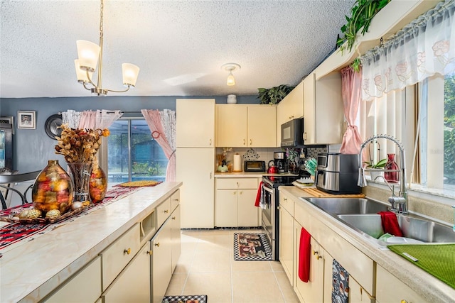 kitchen featuring electric stove, a wealth of natural light, a notable chandelier, and cream cabinetry