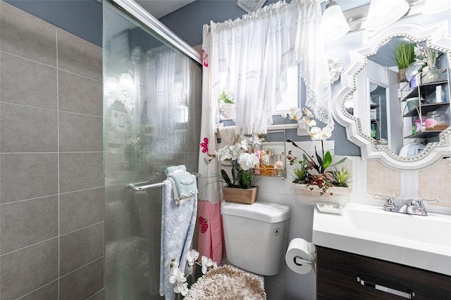 bathroom featuring vanity, toilet, and a shower with door