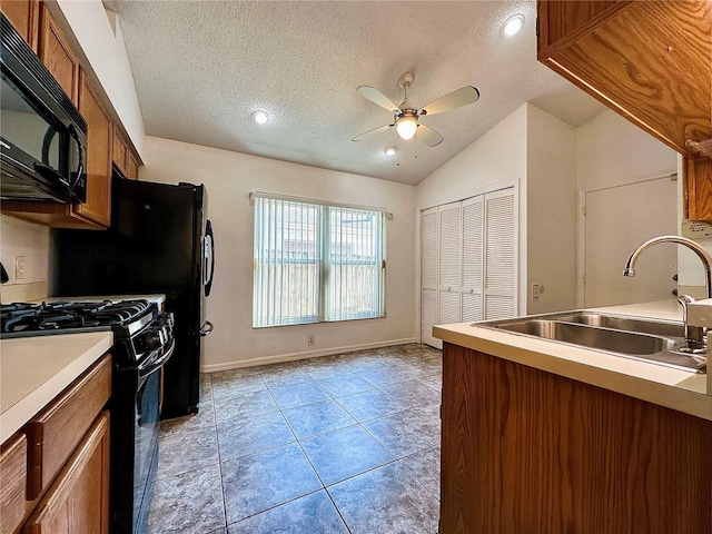 kitchen featuring ceiling fan, sink, a textured ceiling, lofted ceiling, and black appliances