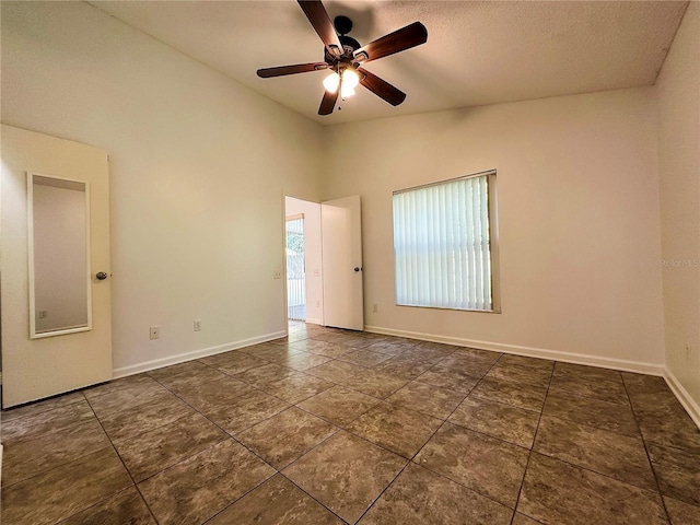 empty room with a textured ceiling, vaulted ceiling, and ceiling fan