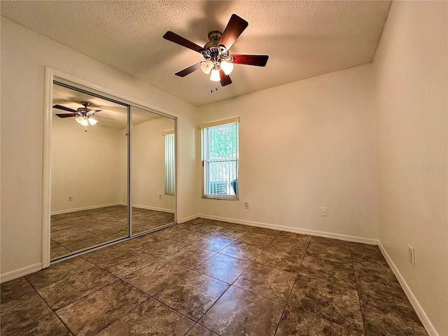 unfurnished bedroom featuring ceiling fan, a textured ceiling, and a closet