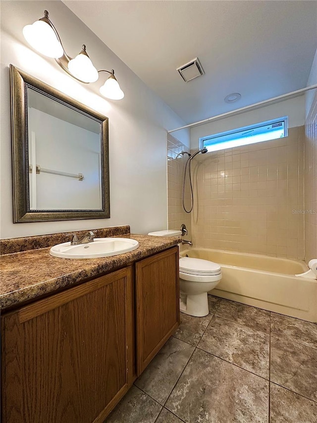 full bathroom featuring tile patterned flooring, toilet, vanity, and tiled shower / bath