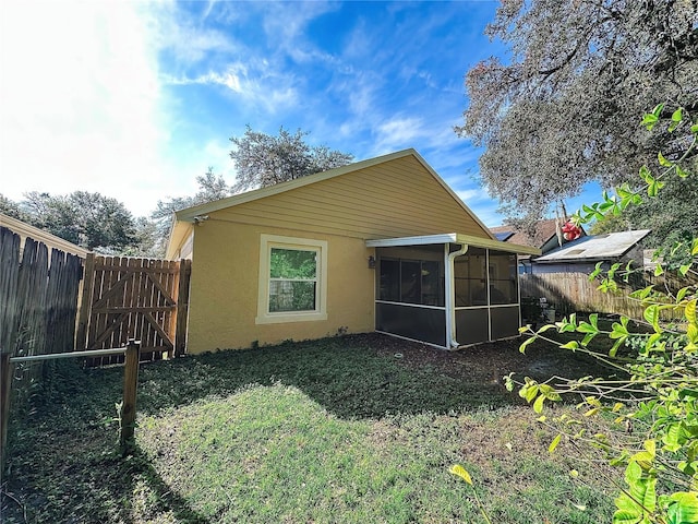 rear view of house featuring a sunroom