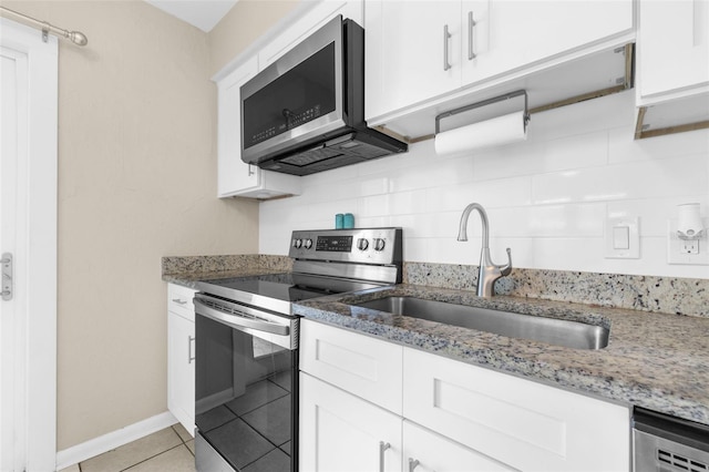 kitchen featuring sink, decorative backsplash, light stone countertops, white cabinetry, and stainless steel appliances