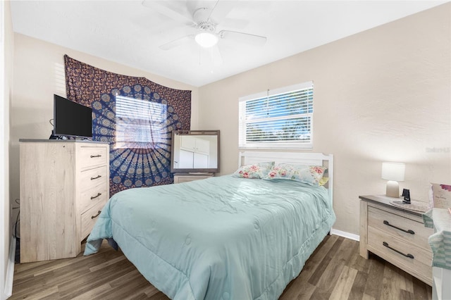 bedroom with dark hardwood / wood-style floors and ceiling fan