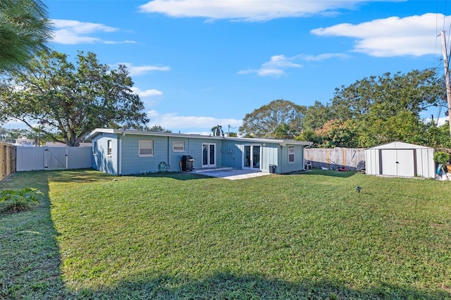 rear view of house featuring a yard, a patio, and a storage unit