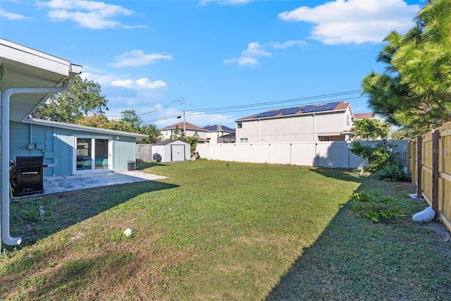 view of yard featuring a storage shed and a patio