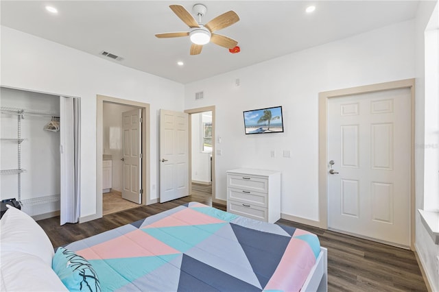 bedroom featuring ceiling fan, ensuite bath, dark wood-type flooring, and a closet