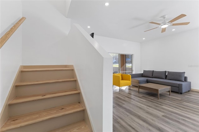 staircase with baseboards, wood finished floors, a ceiling fan, and recessed lighting