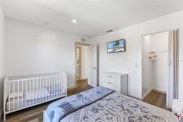 bedroom with baseboards, a closet, visible vents, and dark wood-type flooring