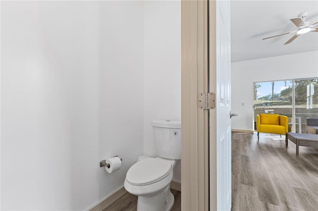 bathroom with toilet, baseboards, a ceiling fan, and wood finished floors