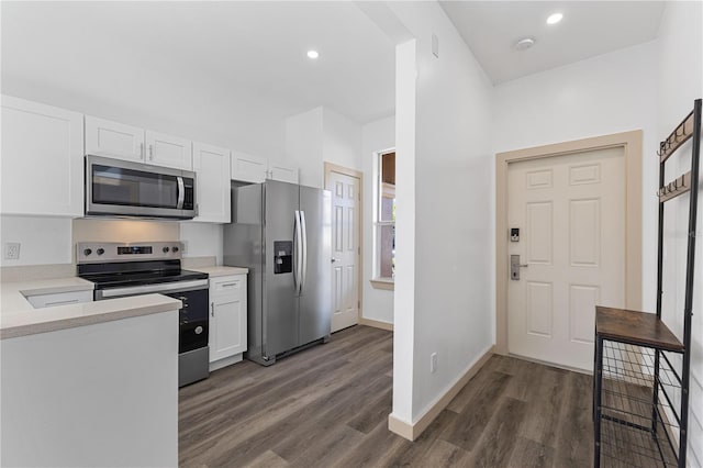 kitchen with dark wood-style floors, stainless steel appliances, light countertops, white cabinets, and baseboards