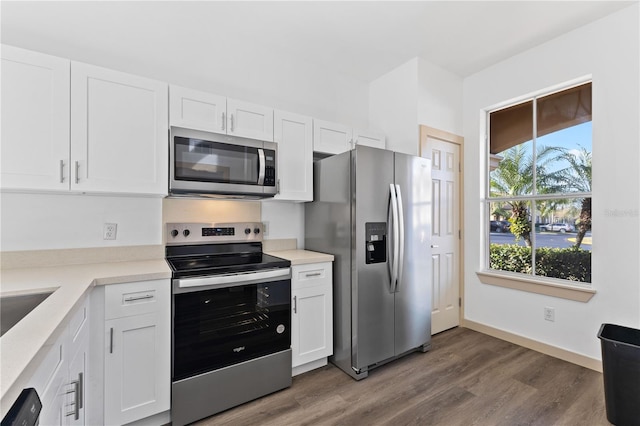 kitchen featuring stainless steel appliances, dark wood-style flooring, light countertops, and white cabinetry