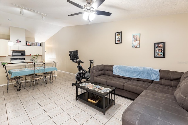 tiled living room with ceiling fan, lofted ceiling, and a textured ceiling