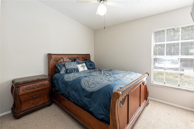 carpeted bedroom with ceiling fan and a textured ceiling