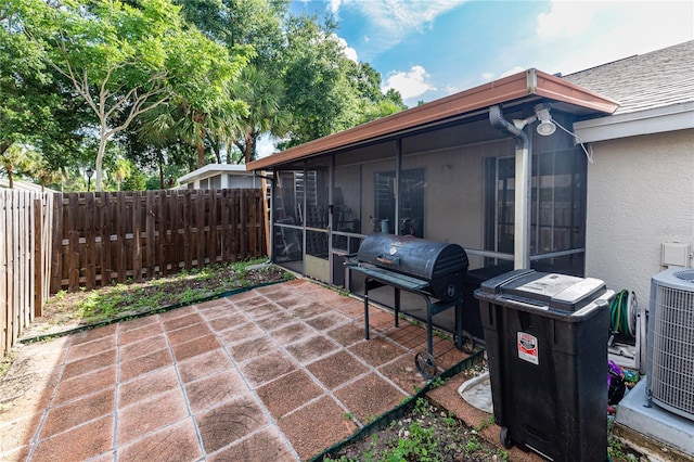 view of patio featuring a sunroom, area for grilling, and central AC