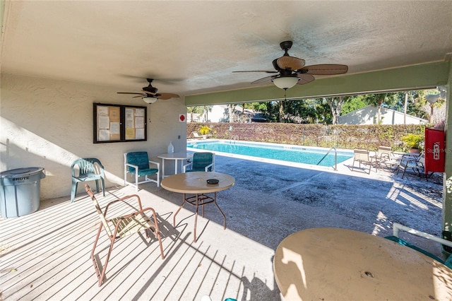 view of pool with ceiling fan and a patio