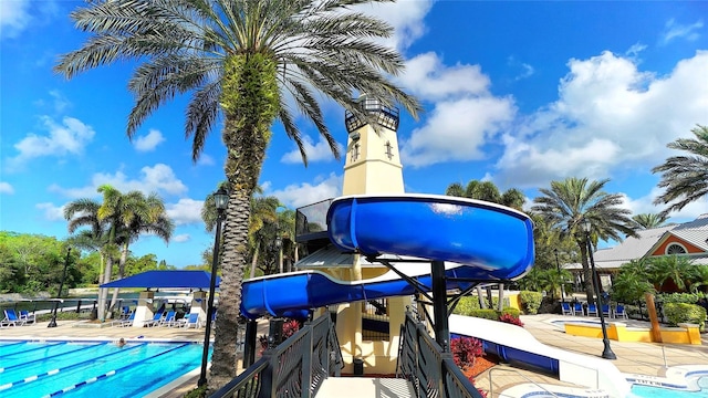 view of swimming pool with a playground and a water slide