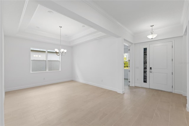 foyer with crown molding, plenty of natural light, a raised ceiling, and a chandelier