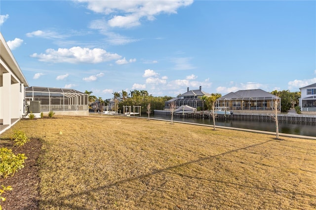 view of yard with a water view, glass enclosure, and cooling unit