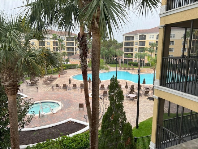 view of swimming pool featuring a patio and a hot tub