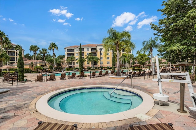 view of pool featuring a community hot tub and a patio