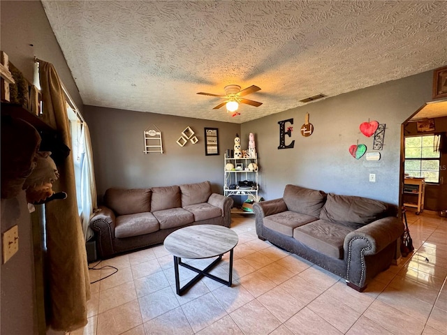 tiled living room featuring a textured ceiling and ceiling fan