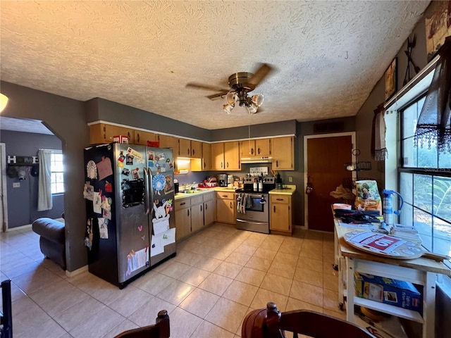 kitchen with ceiling fan, light tile patterned floors, a textured ceiling, and appliances with stainless steel finishes