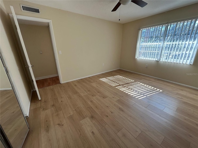 unfurnished bedroom with visible vents, a ceiling fan, baseboards, and wood finished floors