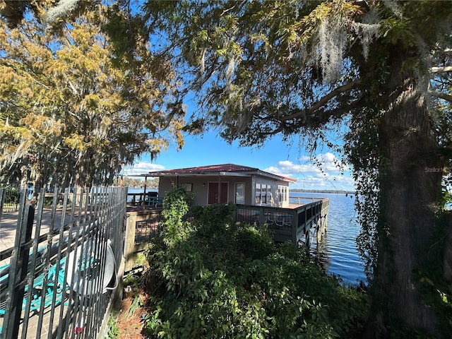 dock area with a water view and fence