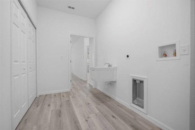 laundry room with washer hookup, sink, hookup for an electric dryer, and light wood-type flooring