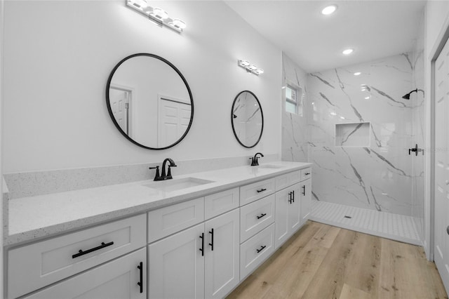 bathroom with vanity, wood-type flooring, and tiled shower