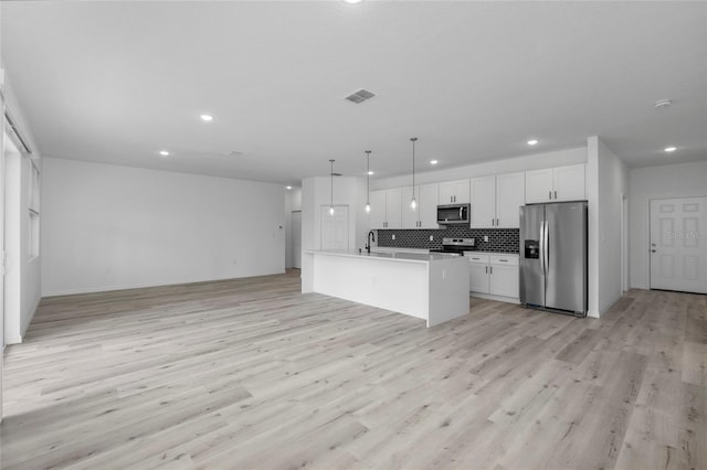 kitchen with white cabinetry, an island with sink, appliances with stainless steel finishes, tasteful backsplash, and decorative light fixtures