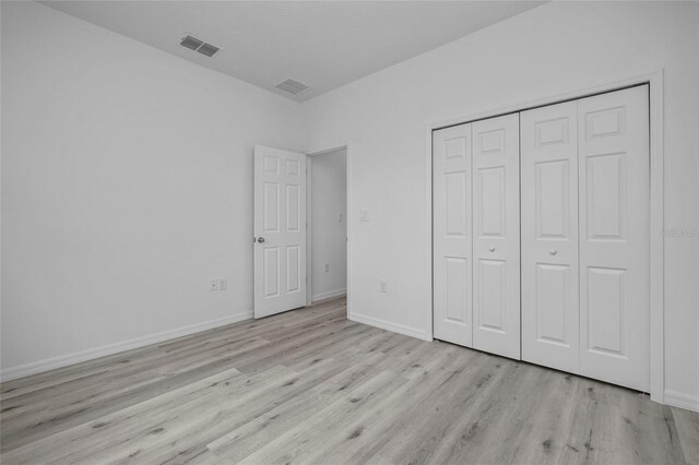 unfurnished bedroom featuring a closet and light hardwood / wood-style flooring