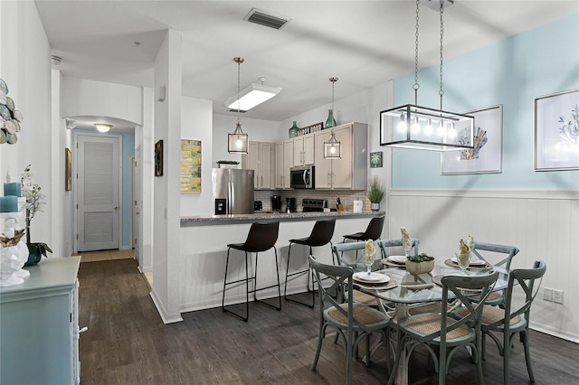 dining space featuring wood walls and dark hardwood / wood-style floors