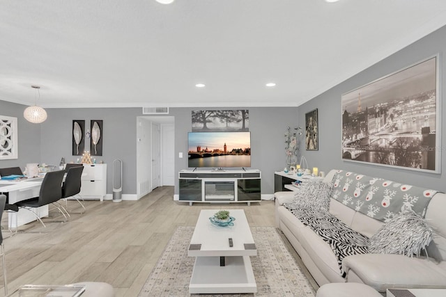 living room with light hardwood / wood-style floors and crown molding