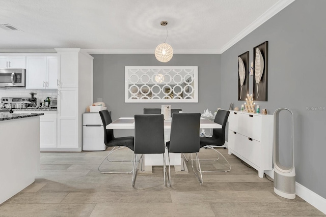 dining room featuring ornamental molding and light hardwood / wood-style floors