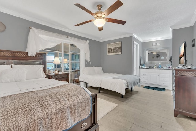 bedroom featuring a textured ceiling, connected bathroom, ceiling fan, light hardwood / wood-style floors, and crown molding