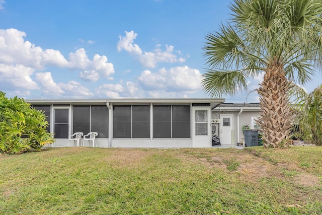 back of house with a yard and a sunroom