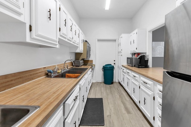 kitchen featuring stainless steel appliances, white cabinets, and sink