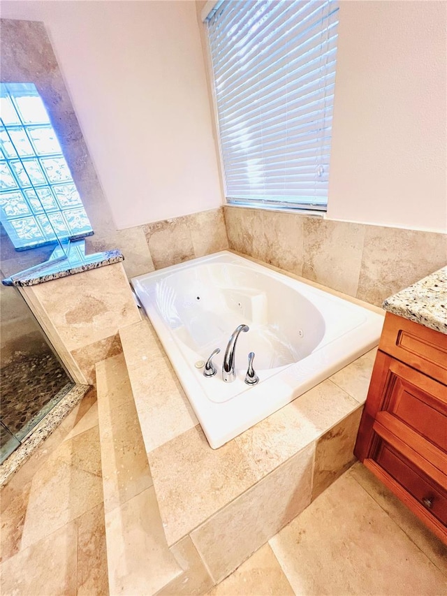 bathroom with vanity and a relaxing tiled tub