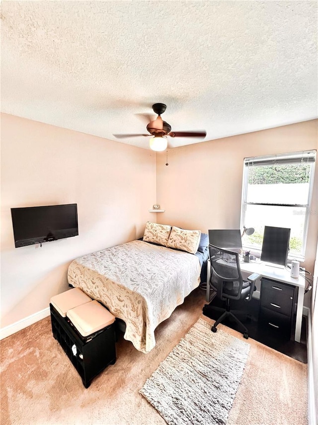 carpeted bedroom with ceiling fan and a textured ceiling