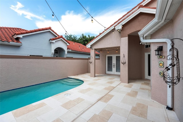 view of swimming pool featuring french doors and a patio