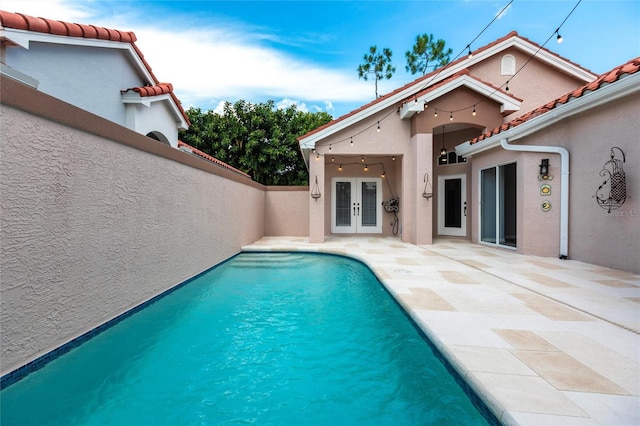 view of swimming pool featuring french doors and a patio